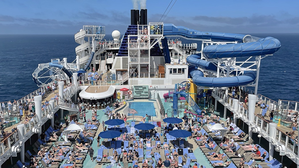 Happy cruisers discovering what is Wave Season on the pool deck of their ship.